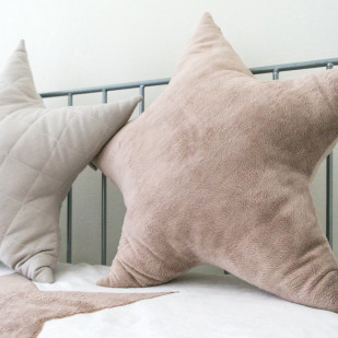 Coussins décoratifs bébé en forme d'étoile, couleurs douces pour une chambre apaisante.