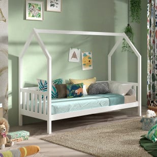 Lit cabane pour enfant en bois blanc avec barrière du fabricant Vipack, décoré de coussins aux motifs végétaux et animaux, installé dans une chambre chaleureuse aux murs verts pastel.