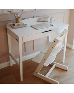Bureau enfant en bois peint en blanc, avec tiroir central, chaise évolutive assortie, et accessoires de bureau dans un intérieur doux aux tons pastel.