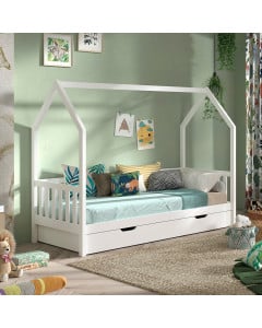 Lit cabane enfant blanc avec barrière latérale et tiroir de rangement intégré Vipack, installé dans une chambre douce et lumineuse décorée de coussins colorés et d'accessoires aux motifs naturels.