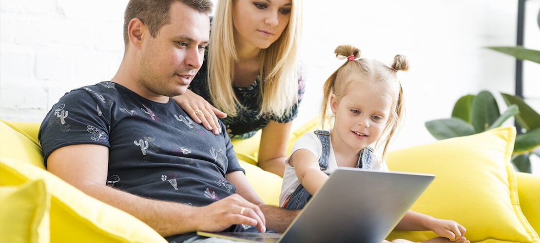Jeune parent avec leur petite fille qui réalise un plan d'aménagement pour la chambre de leur enfant créé avec une application ou un site web