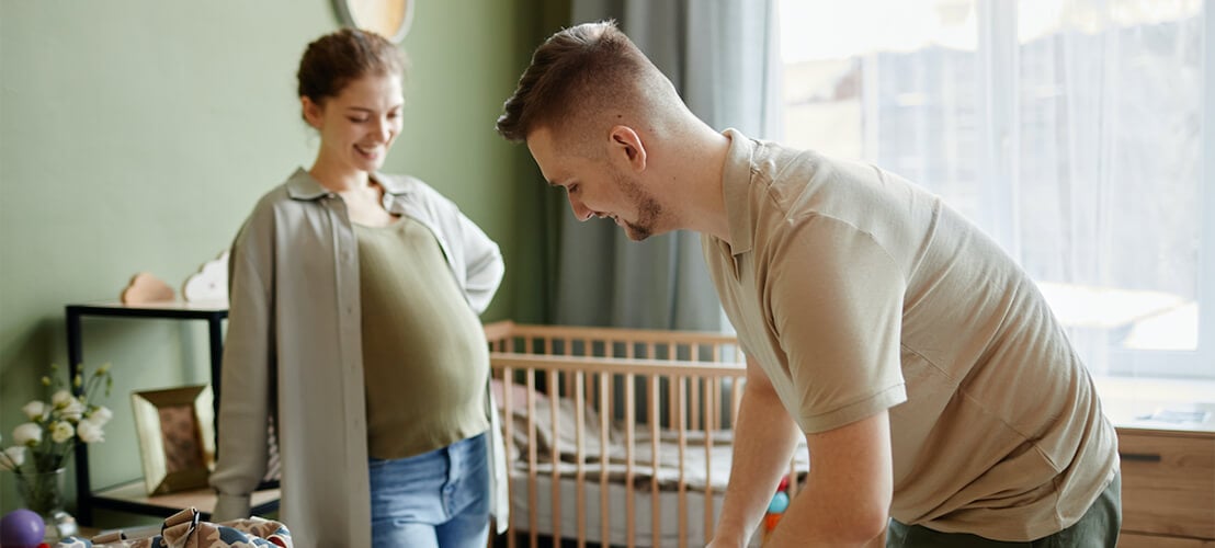 Jeune parent qui prépare la chambre de bébé avec une literie DIY