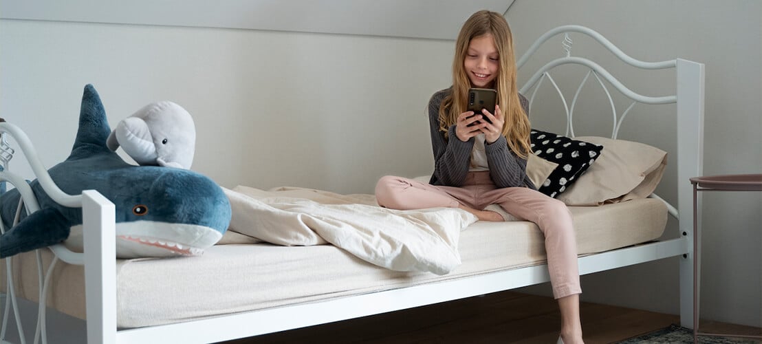 Jeune fille assise sur son lit 90x190 - un choix de taille durable pour tous les âges