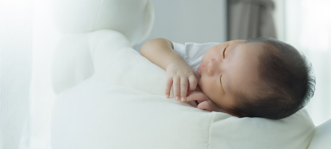 Photo d’un mignon bébé garçon qui dort dans un lit moelleux paisiblement