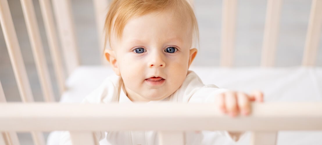 Bébé mignon dans un lit à barreaux