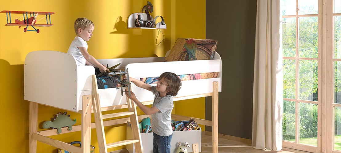 Image de deux enfants qui joue sur un lit surélevé