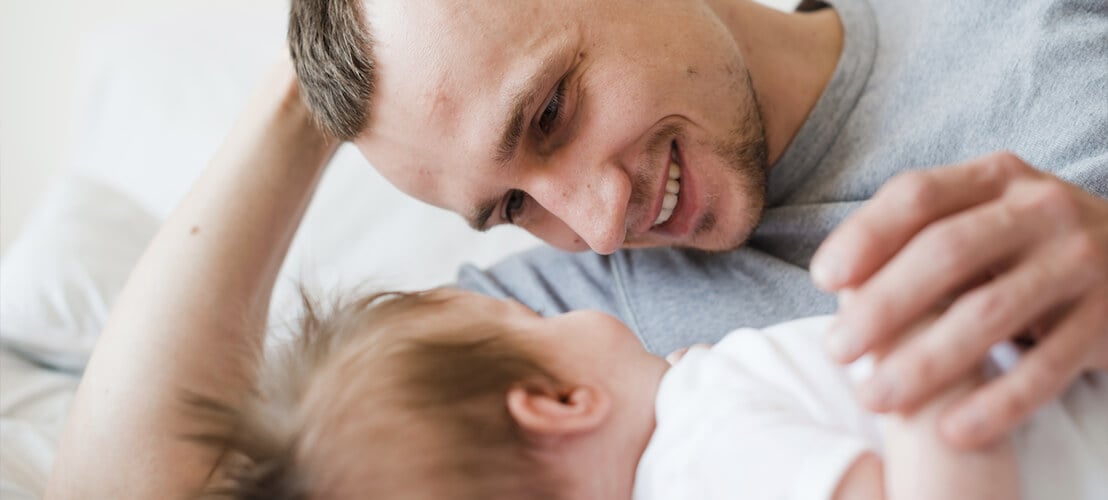 Photo d’un père couché avec bébé au lit