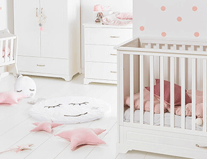 Chambre bébé Melo blanche avec lit à barreaux, commode et armoire dans une déco douce avec touches roses